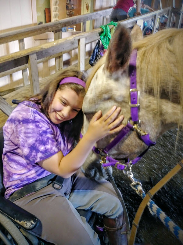 Image of individual hugging a horse